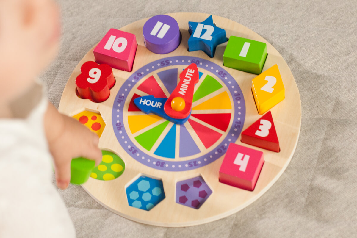 Image of a child having fun playing with What Time Is It? Glow-In-The-Dark Clock Puzzle