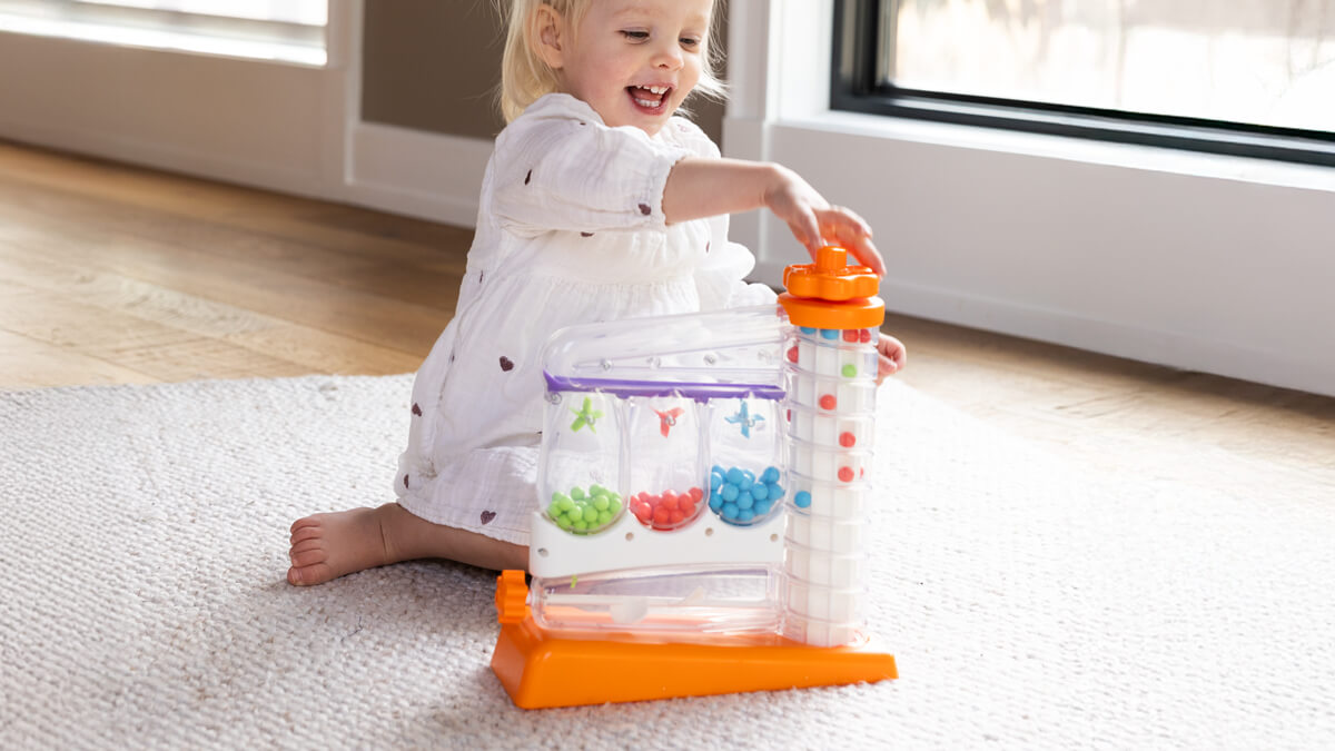 Smiling child sitting by a window playing with SortAgain!