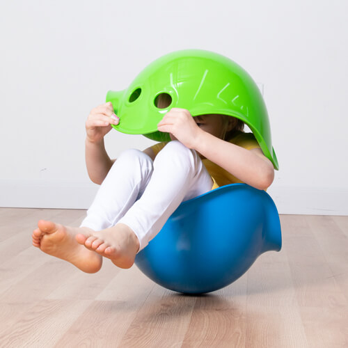 Child sitting in a blue bilibo and looking through a green bilibo!